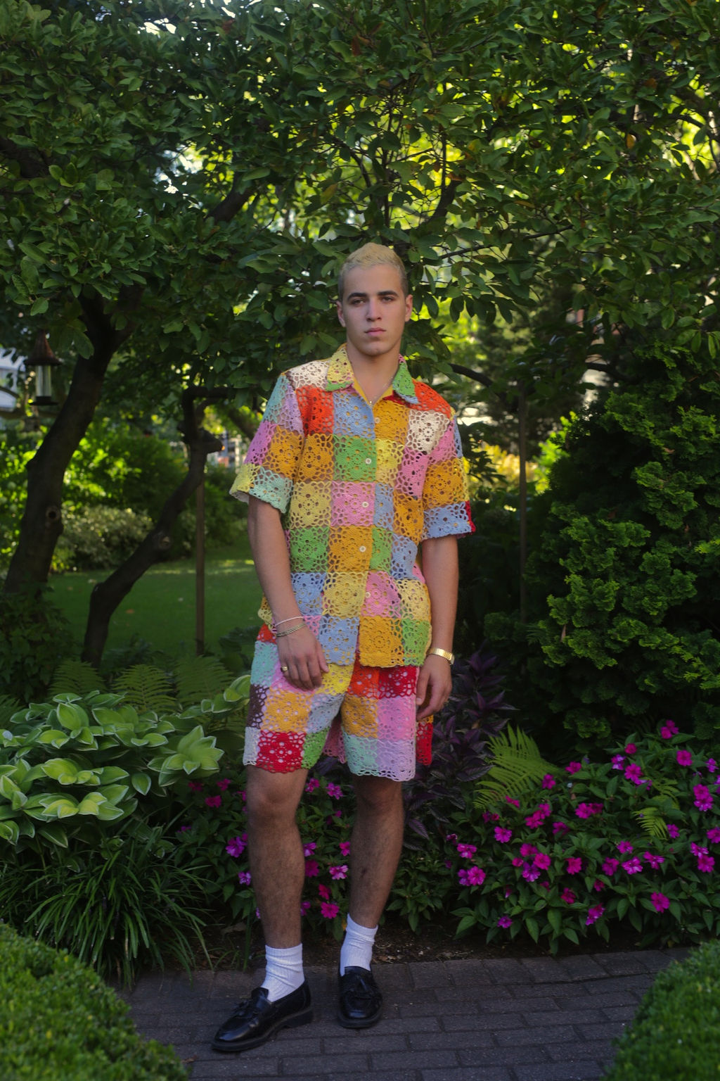 model wears a rainbow crochet button down shirt