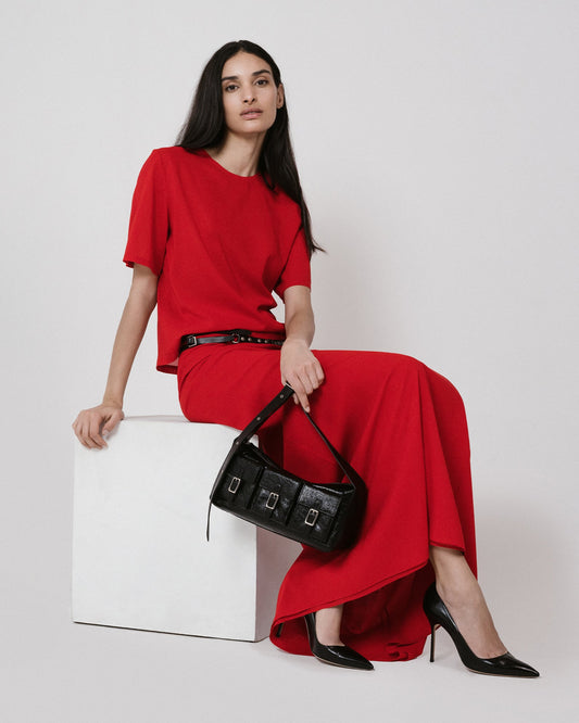 red shirt and skirt black bag sitting