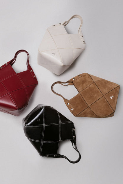 Four handbags in red, white, black, and brown on a light gray background